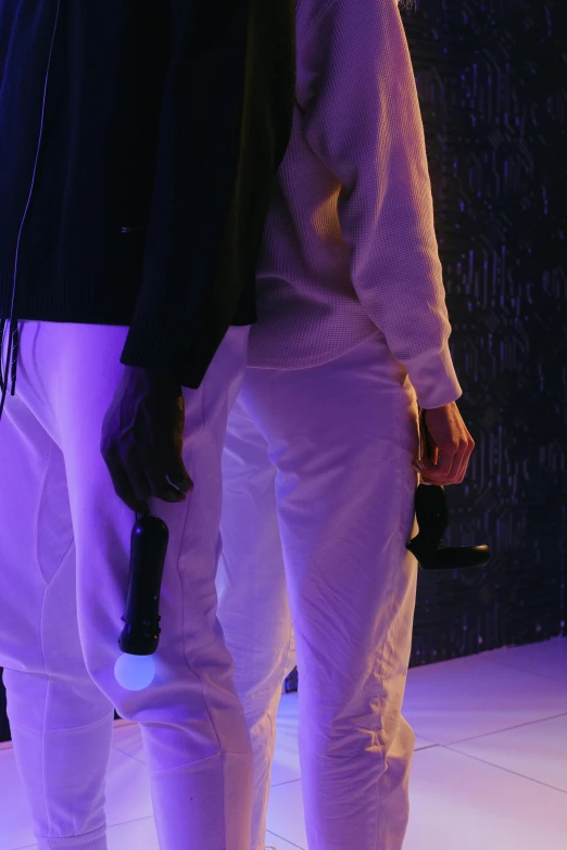 a couple of people standing next to each other on a stage, by Ottó Baditz, happening, fluo details, wearing white pajamas, holding ego weapons, detail shot