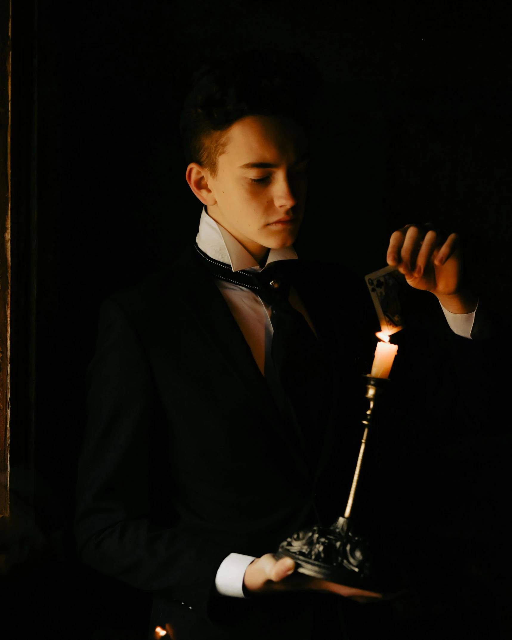 a man in a tuxedo holding a lit candle, inspired by Karl Bryullov, pexels contest winner, bisexual lighting, profile image, album cover, victorian clothing