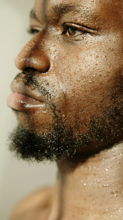 a close up of a man with a beard, by Matija Jama, trending on pexels, hyperrealism, sweaty wet skin, man is with black skin, face profile, photographed for reuters