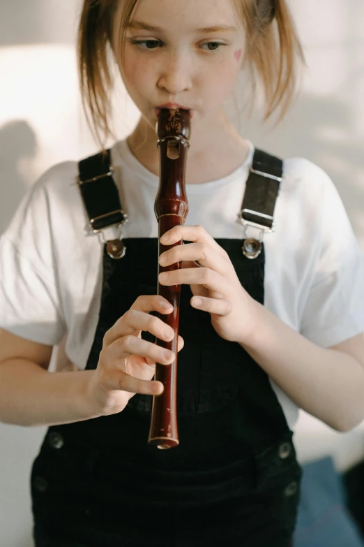 a little girl that is playing a musical instrument, an album cover, pexels contest winner, hand carved brown resin, with pipes attached to it, premium quality, smol