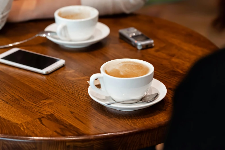 a couple of cups of coffee sitting on top of a wooden table, by Sven Erixson, trending on pexels, profile image, thumbnail, high quality photo, uk