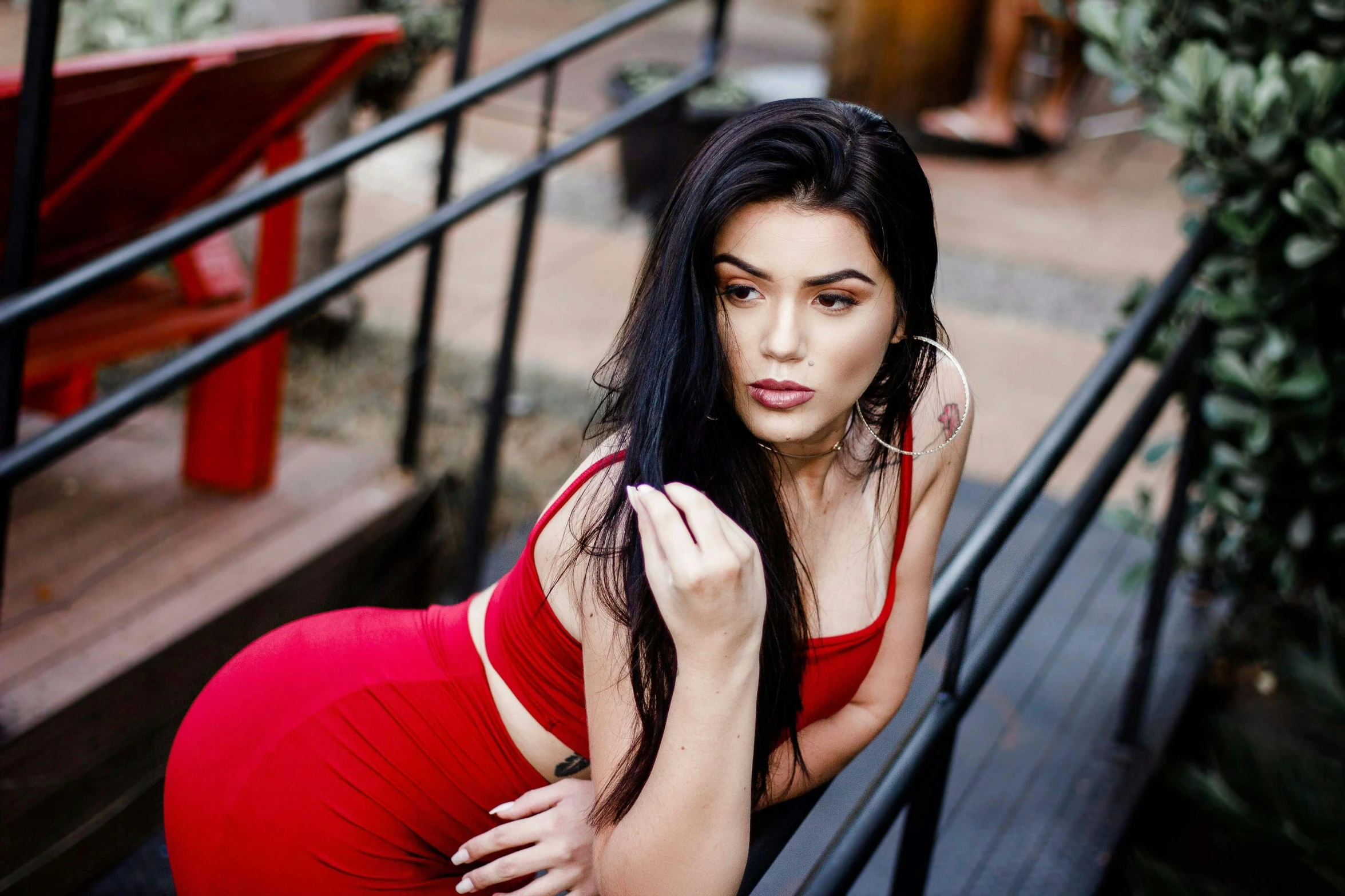 a woman in a red dress sitting on a bench, instagram, hurufiyya, very sexy woman with black hair, profile image, 21 years old, brazilian