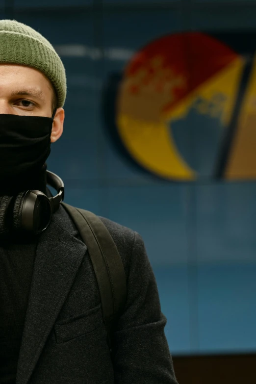 a man wearing a black jacket and a green hat, an album cover, by Adam Marczyński, trending on pexels, balaclava mask, in a subway, wearing turtleneck, eastern european