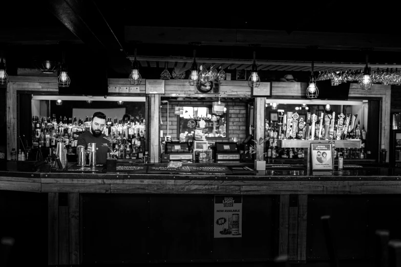 a black and white photo of a bar, a portrait, by Jay Hambidge, pexels, private press, it's night time, iconostasis in the bar, buying beers in the british bar, slightly sunny