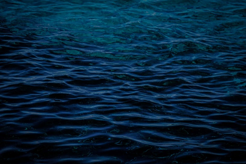 a boat floating on top of a body of water, by Elsa Bleda, hurufiyya, dark blue water, ripples, a close-up, (night)