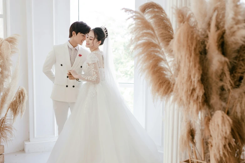 a bride and groom standing next to each other, inspired by Kim Du-ryang, pexels contest winner, romanticism, white room, background image, ao dai, straw