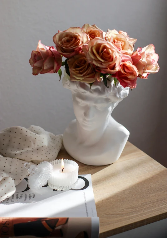 a vase filled with flowers sitting on top of a wooden table, a marble sculpture, inspired by Pierre-Joseph Redouté, trending on pinterest, romanticism, coral headdress, cozy candlelight, face shown, medium gargoyle soft light