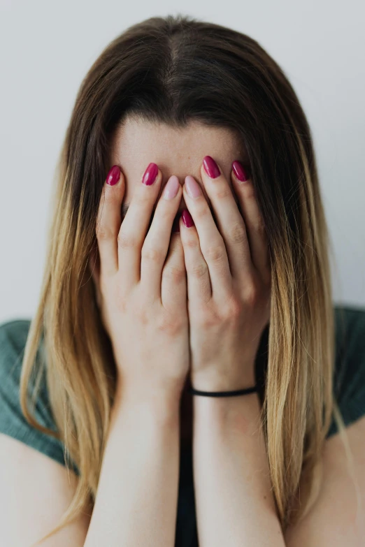 a woman covering her face with her hands, pexels, tear drop, embarrassing, young woman in her 20s, multiple stories