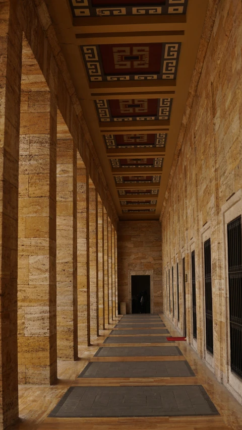 a long hallway with a clock hanging from the ceiling, inspired by David Chipperfield, pexels contest winner, in giza, colonnade, brown, rectangular