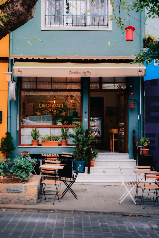 a building with tables and chairs in front of it, trending on unsplash, cute bakery shop, greece, thumbnail, full body image