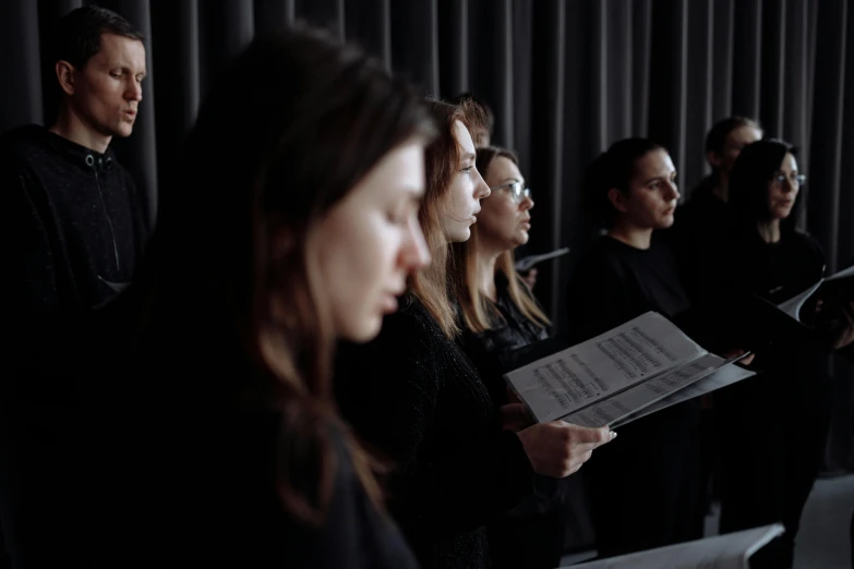 a group of people standing next to each other, an album cover, by Matija Jama, unsplash, antipodeans, choir, woman in black robes, performance, profile image