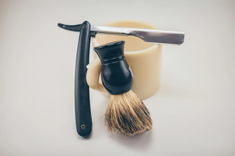 a close up of a shaving brush and a razor, unsplash, purism, miscellaneous objects, ivory and ebony, ultra realistic, 90s photo
