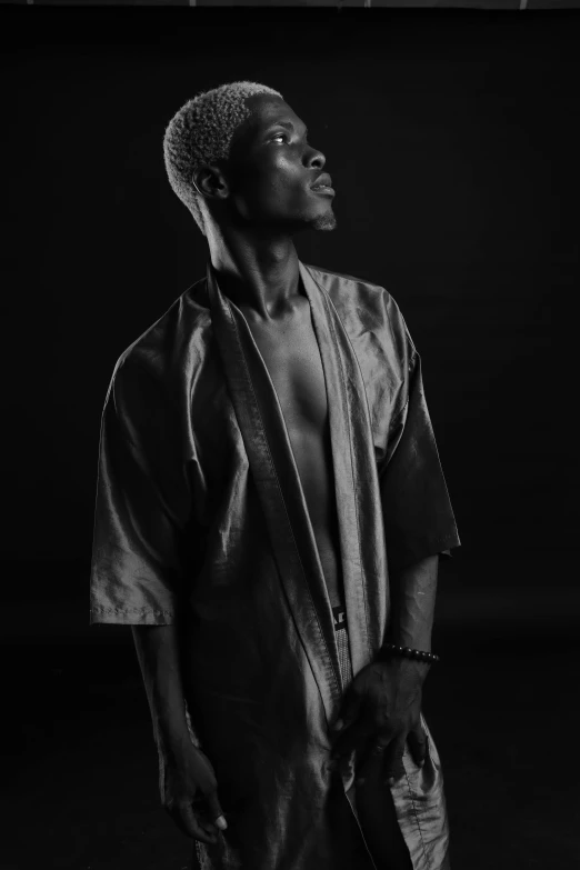 a black and white photo of a man in a robe, unsplash, lil uzi vert, loin cloth, side lighting, a silver haired mad