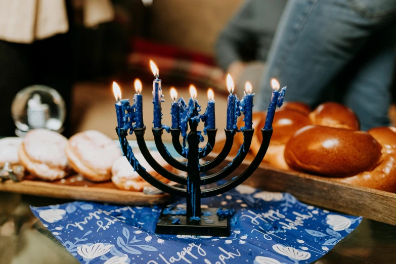 a menorah with lit candles sitting on a table, by Julia Pishtar, trending on unsplash, blue print, fully decorated, instagram post, high resolution product photo