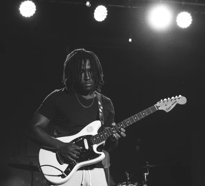 a man with dread dread dread dread dread dread dread dread dread dread dread dread dread dread dread, pexels contest winner, black arts movement, playing electric guitar, chief keef, on a stage, dark and white