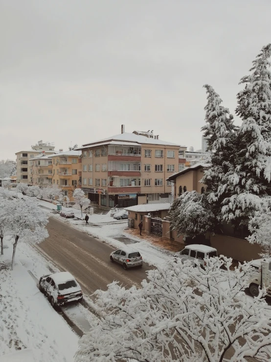 a street filled with lots of snow next to tall buildings, by Niyazi Selimoglu, hurufiyya, pamukkale, neighborhood outside window, low quality photo, high res 8k