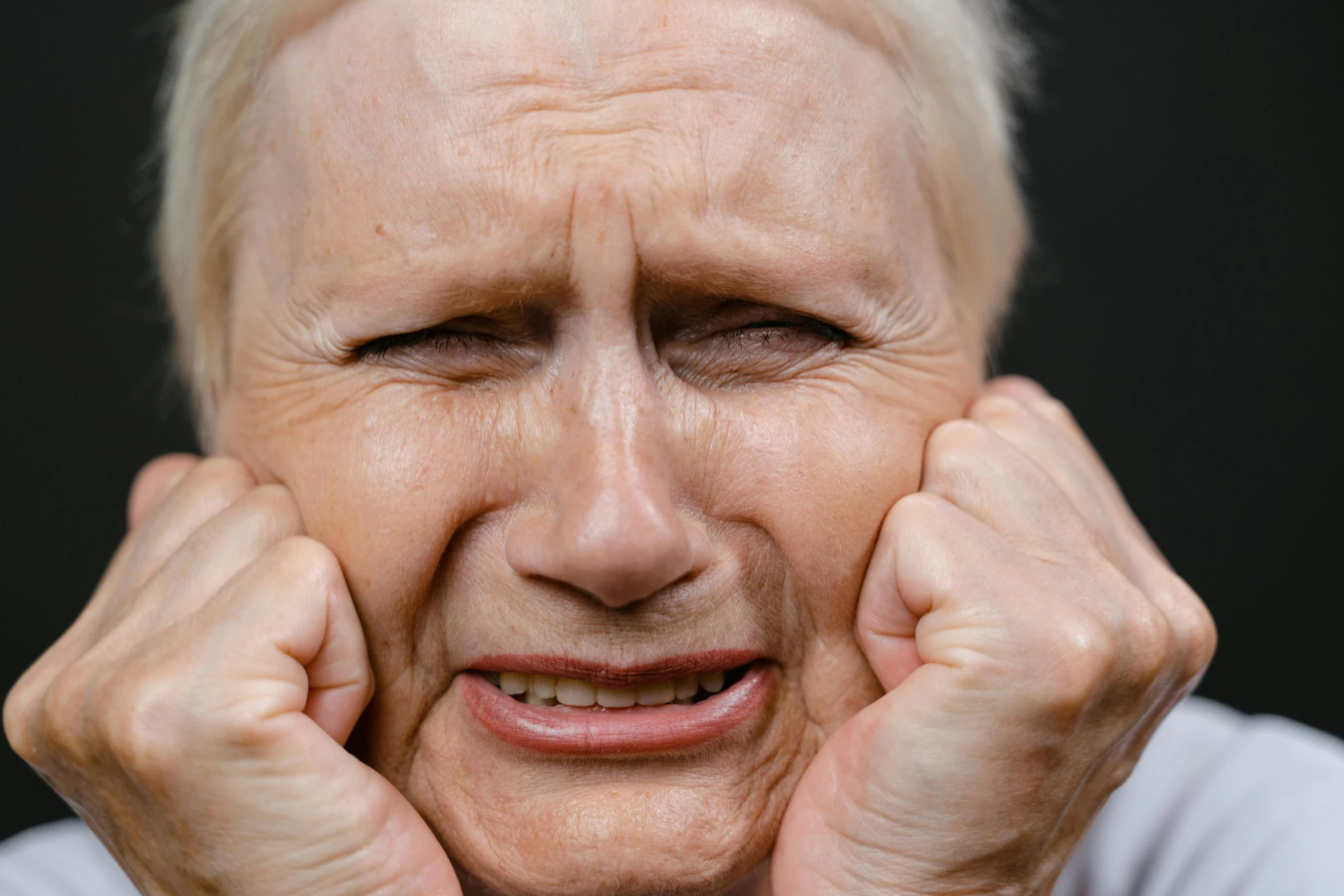 a close up of a person holding their hands to their face, grimacing, wrinkles, uploaded, freezing