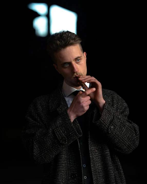 a man smoking a cigarette in a dark room, an album cover, inspired by Thomas Wijck, pexels contest winner, bauhaus, ryan gosling, wearing wool suit, ( ( theatrical ) ), editorial model