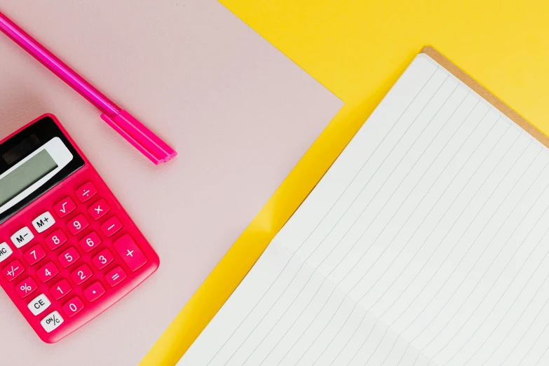 a pink calculator sitting on top of a desk next to a notebook, by Julia Pishtar, pexels, yellow theme, background image, no - text no - logo, bright colours