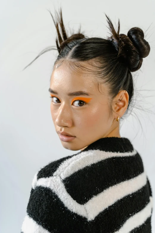 a woman wearing a black and white striped sweater, inspired by Russell Dongjun Lu, trending on pexels, realism, orange highlights, bun, ethnicity : japanese, looks a blend of grimes