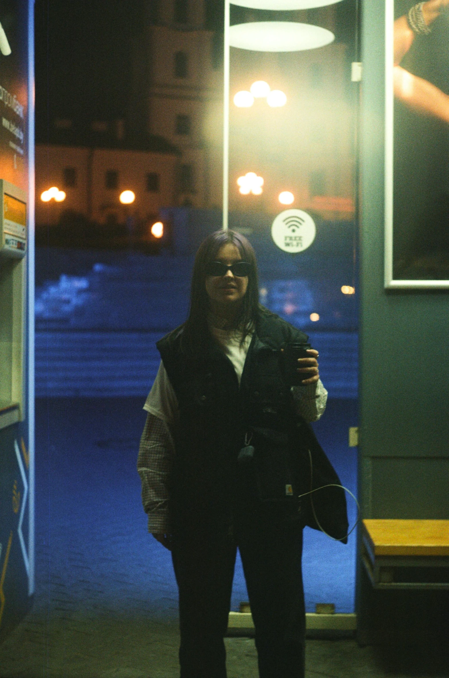 a woman standing in front of a bus at night, inspired by Elsa Bleda, dark glasses, with his long black hair, photo 1998, helsinki