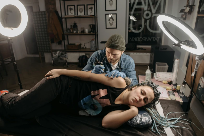 a man getting a tattoo on a woman's arm, a tattoo, by Adam Marczyński, pexels contest winner, down left arm and back, airbrush style, akali, 90's photo