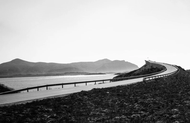 a black and white photo of a curved road, by Altichiero, mountains and ocean, medium format film photography, :: morning, bjørn skalldrasson