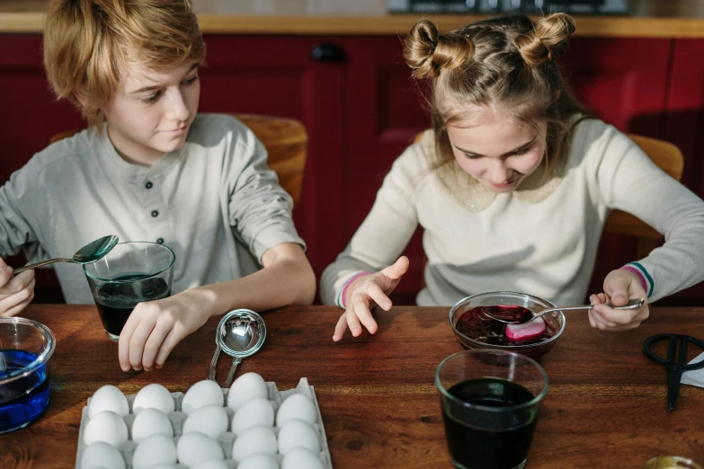 a couple of kids that are sitting at a table, pexels contest winner, eggs, making a potion, hard boiled, casual game