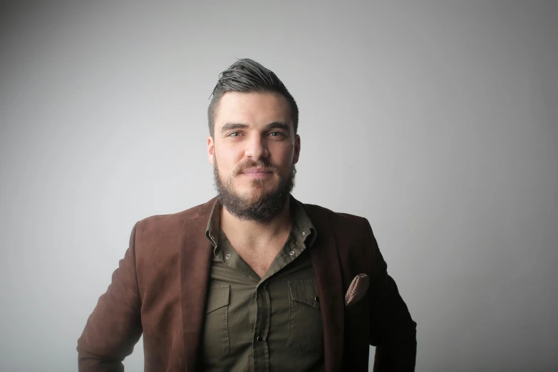 a man with a beard wearing a brown jacket, pexels contest winner, in front of white back drop, elias chatzoudis, casually dressed, edin durmisevic