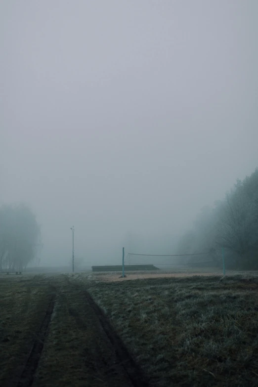 a bench sitting in the middle of a field on a foggy day, inspired by Elsa Bleda, postminimalism, soviet town, volley court background, ((mist)), alexey gurylev