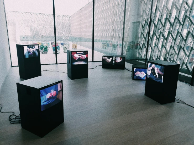 a group of televisions sitting on top of a wooden floor, by Magdalene Bärens, unsplash, video art, inside a glass box, exhibition display, embracing, amanda clarke