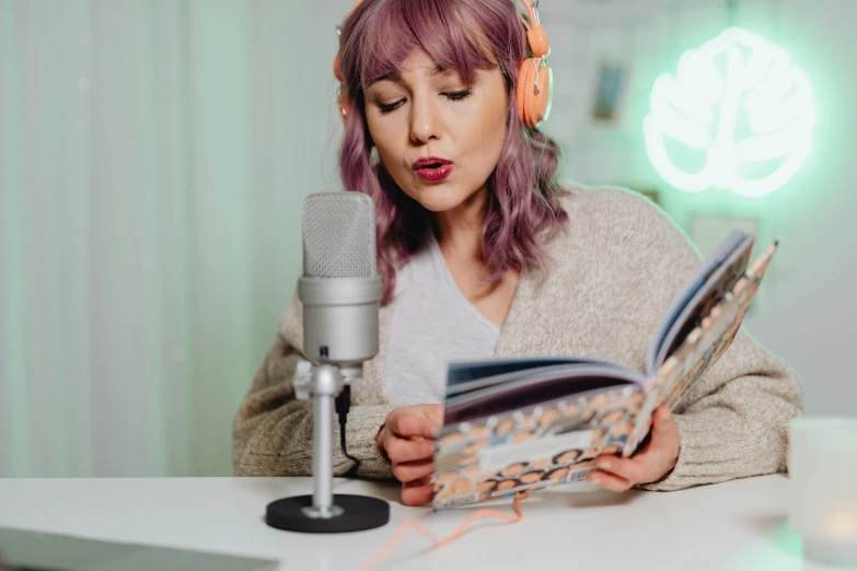 a woman reading a book while wearing headphones, trending on pexels, singing into microphone, avatar image, astri lohne, high quality image