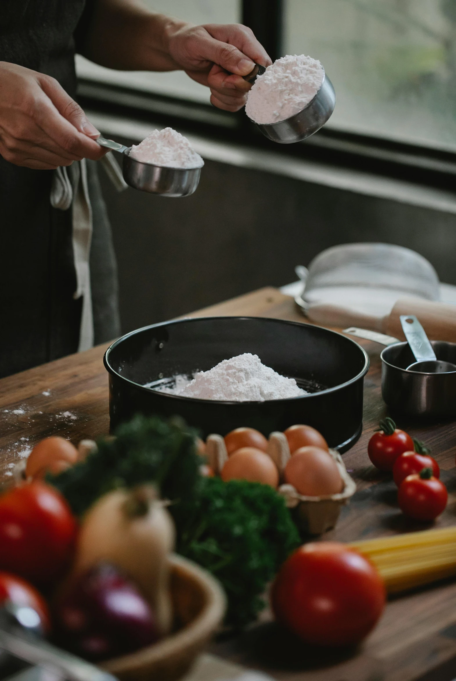 a person in a kitchen preparing food on a cutting board, a still life, pexels contest winner, pots and pans, covered in white flour, ingredients on the table, landscape shot