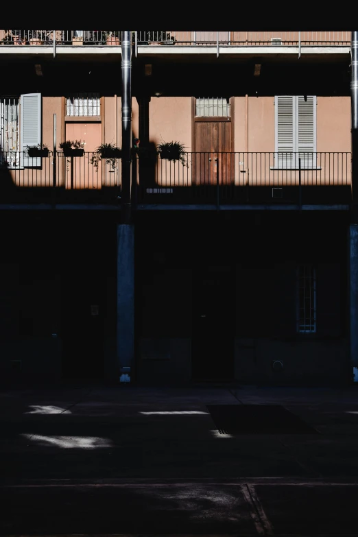 a person riding a skateboard on a city street, a picture, unsplash, postminimalism, french village exterior, dark. no text, square, balconies