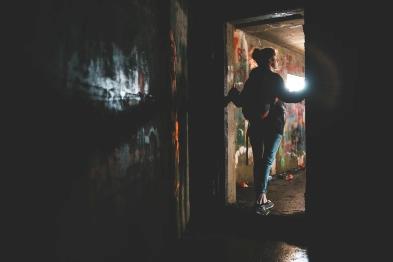 a man holding a flashlight in a dark room, inspired by Elsa Bleda, pexels contest winner, graffiti, grungy woman, inside the tunnel, instagram post, grungy; colorful