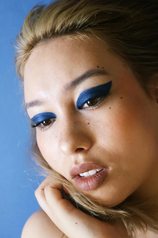 a woman with blue eyes is posing for a picture, an album cover, inspired by Natasha Tan, trending on pexels, winged eyeliner, young asian woman, navy, portrait sophie mudd