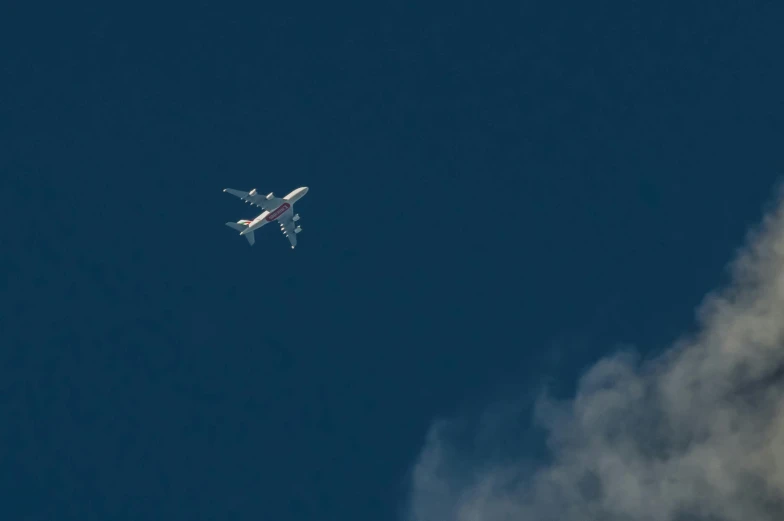 a large jetliner flying through a blue sky, a picture, unsplash, hurufiyya, low quality photo, shmup, flying emergency vehicles, viewed from very far away