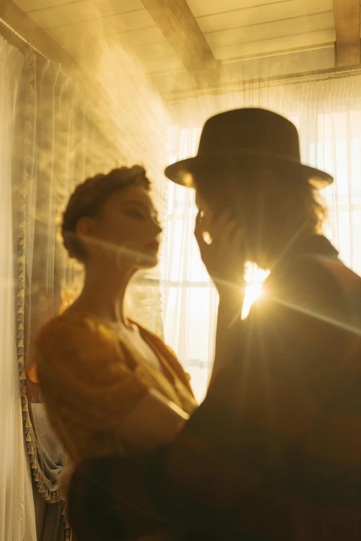 a man and a woman standing in front of a window, unsplash, romanticism, gold ethereal light, spaghetti western, film still, kiss