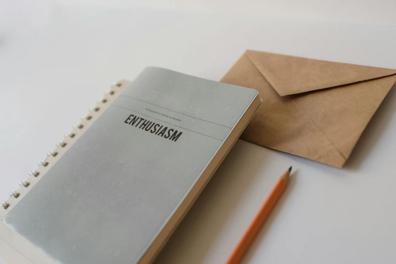 a notebook sitting on top of a table next to a pencil, unsplash contest winner, letterism, amused, embossed, email, thumbnail