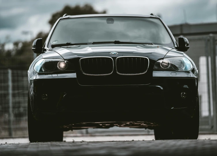 a black bmw suv parked in a parking lot, pexels contest winner, a head-on, 256435456k film, hyperdetail, car jump