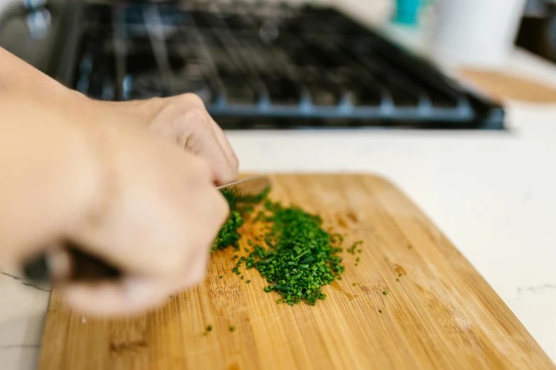 a person chopping herbs on a cutting board, by Carey Morris, pexels contest winner, process art, slightly pixelated, tanjiro kamado, embarrassing, extra crisp image