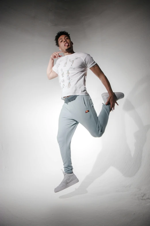 a man jumping in the air with a skateboard, inspired by Ma Quan, arabesque, pale blue outfit, official store photo, zyzz, wearing cargo pants