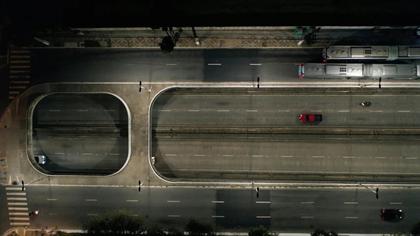 an overhead view of a city street at night, by Alejandro Obregón, pexels contest winner, hyperrealism, red car, overpass, movie frame still, still from film