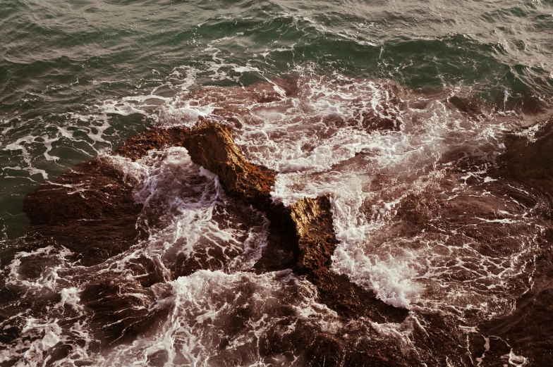 a large rock in the middle of a body of water, an album cover, by Elsa Bleda, unsplash, romanticism, turbulent waves, ignant, stephen shore, 'untitled 9 '