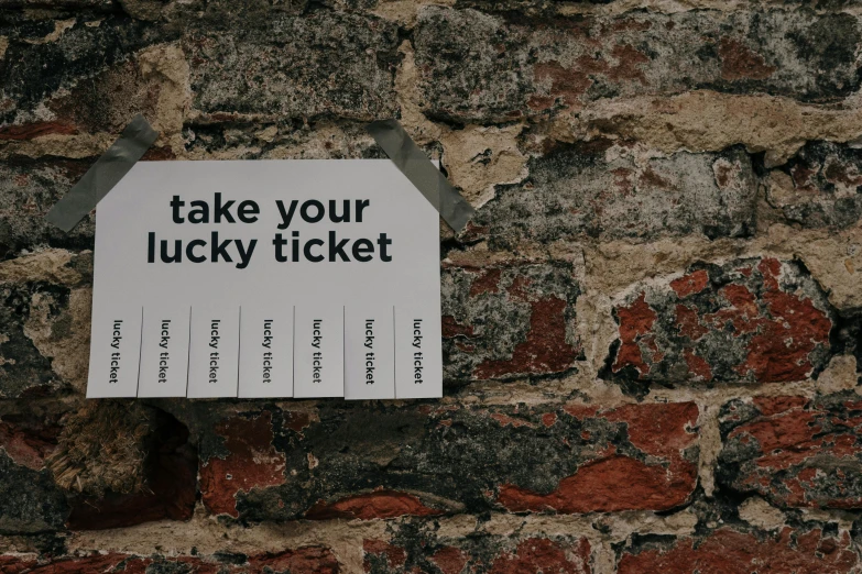 a sign on a brick wall that says take your lucky ticket, pexels contest winner, fluxus, takeyuki kanda, thumbnail, dreamy, ad image