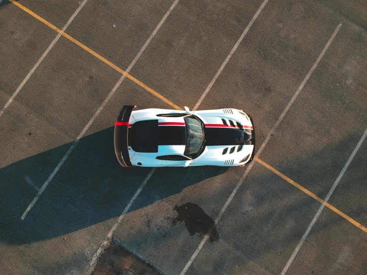 a white sports car parked in a parking lot, pexels contest winner, hypermodernism, high angle uhd 8 k, striped, race track background, long shadow