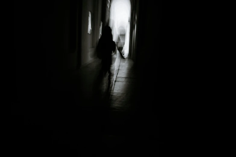 a person walking down a dark hallway with a cane, a black and white photo, inspired by Katia Chausheva, pexels contest winner, light and space, people running in fear, ghosts, silhouette, pinhole effect