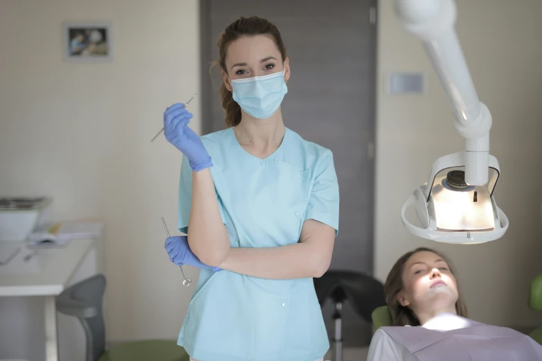 a woman is getting her teeth examined by a dentist, a portrait, by Adam Marczyński, pexels contest winner, hurufiyya, avatar image, surgical gown and scrubs on, tiffany dover, thumbnail