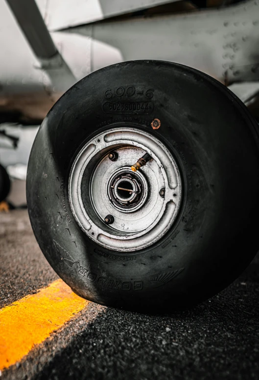 a close up of a tire on a plane, pexels contest winner, on the runway, fighter jet, black. airports, deep dish wheels