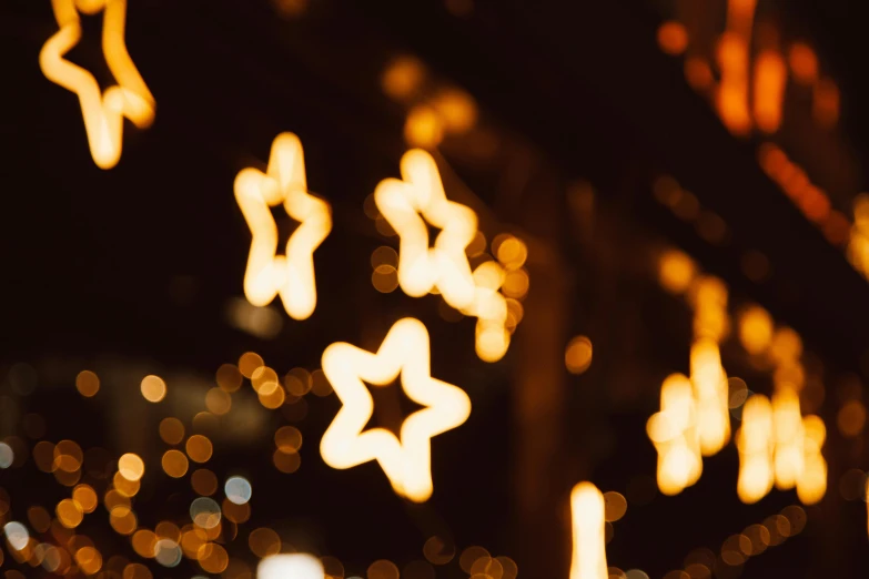 a bunch of lights that are on the side of a building, by Julia Pishtar, pexels, star inside, ornaments, cutest, golden embers flying